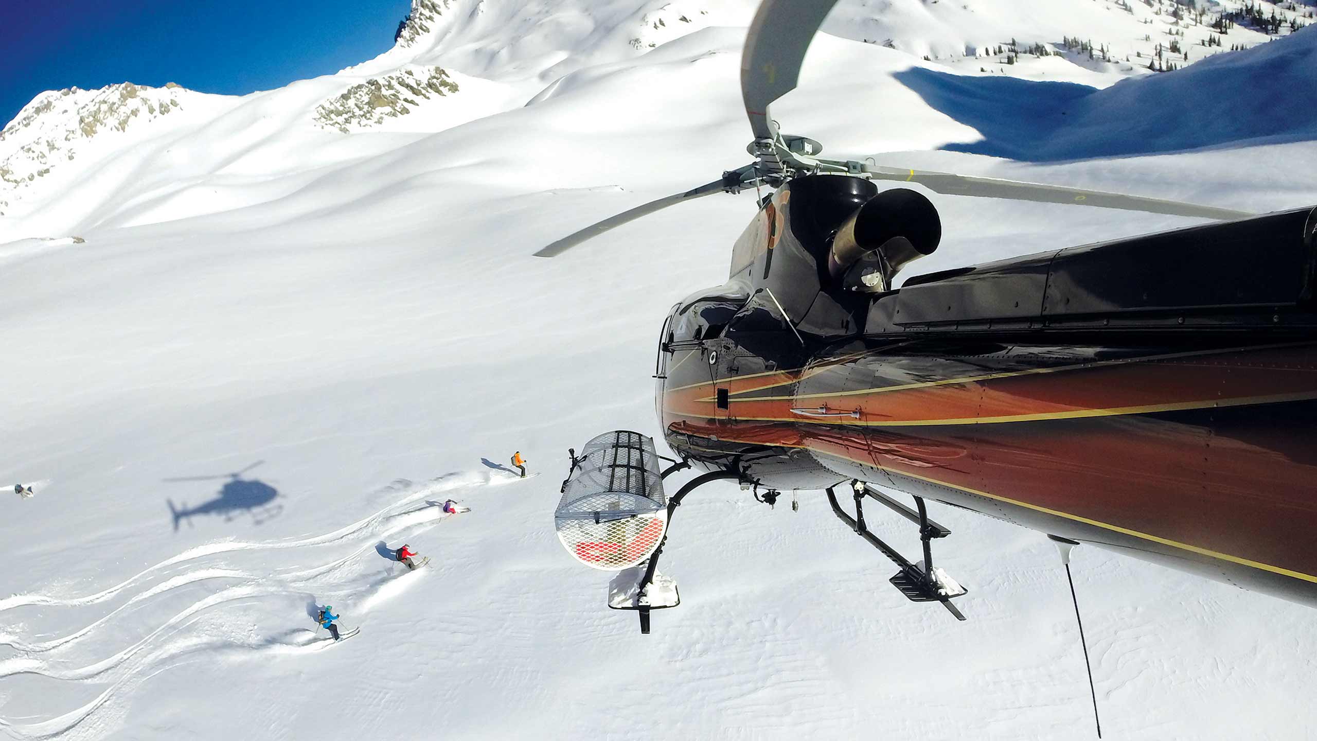 Heli-Ski Group with Helicopter Above