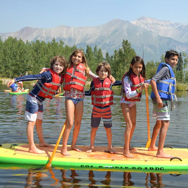 Six kids on a paddleboard in Telluride.