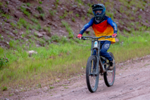 10-year old boy enjoying the thrill of mountain biking at Telluride Ski Resort's Kids Grom Camps.